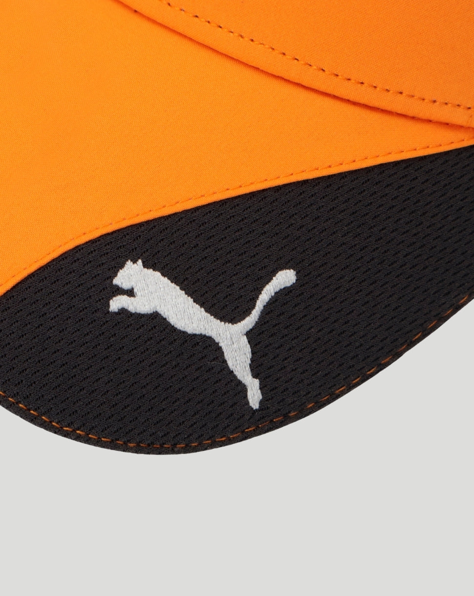 Close up of orange cap fabric showing white Puma logo on a black patch
