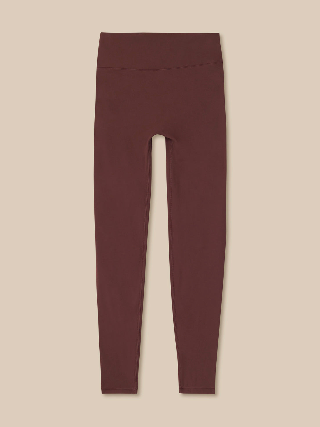 Maroon leggings on a beige background