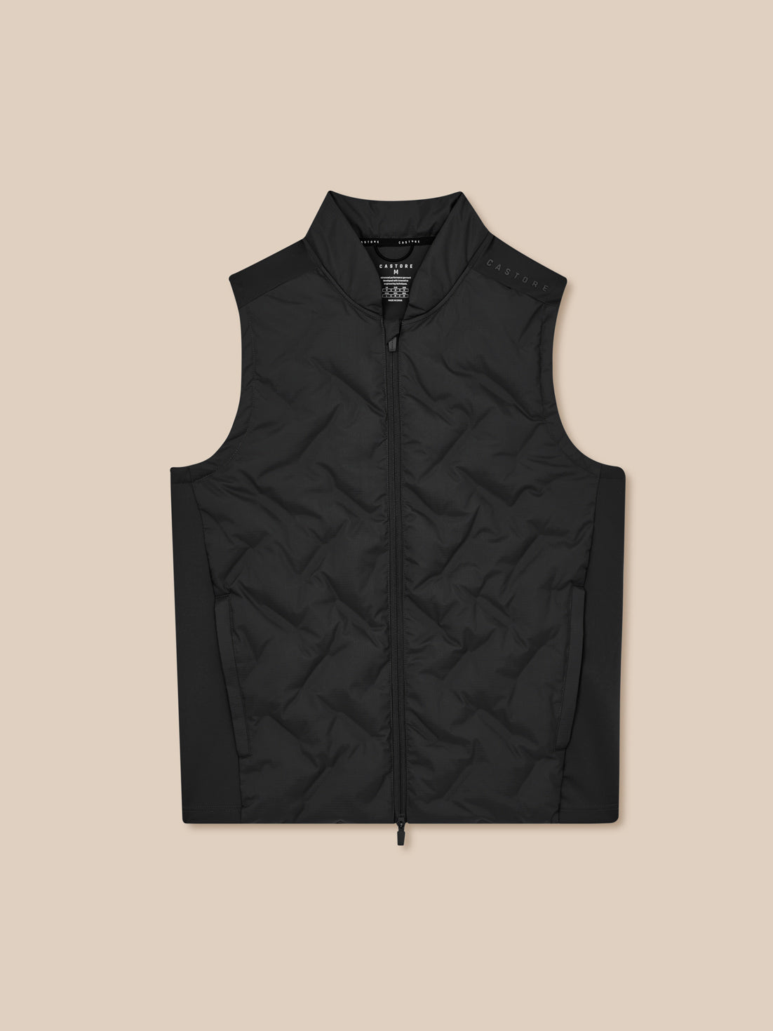 Black quilted vest on a beige background