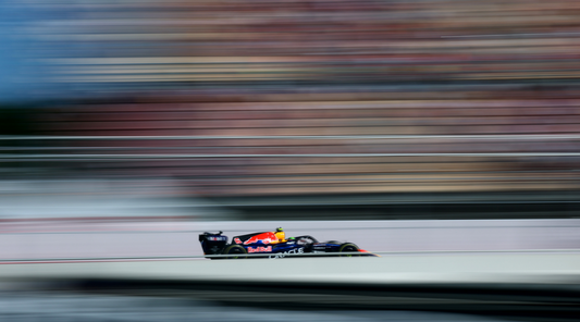 Red Bull Formula 1 car speeds along a track with a horizontal motion blur background.