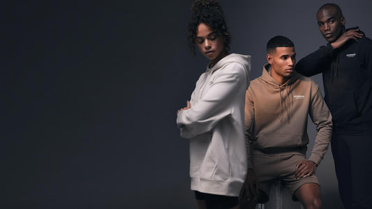 Three models wearing Upgrade hoodies pose against a dark studio backdrop