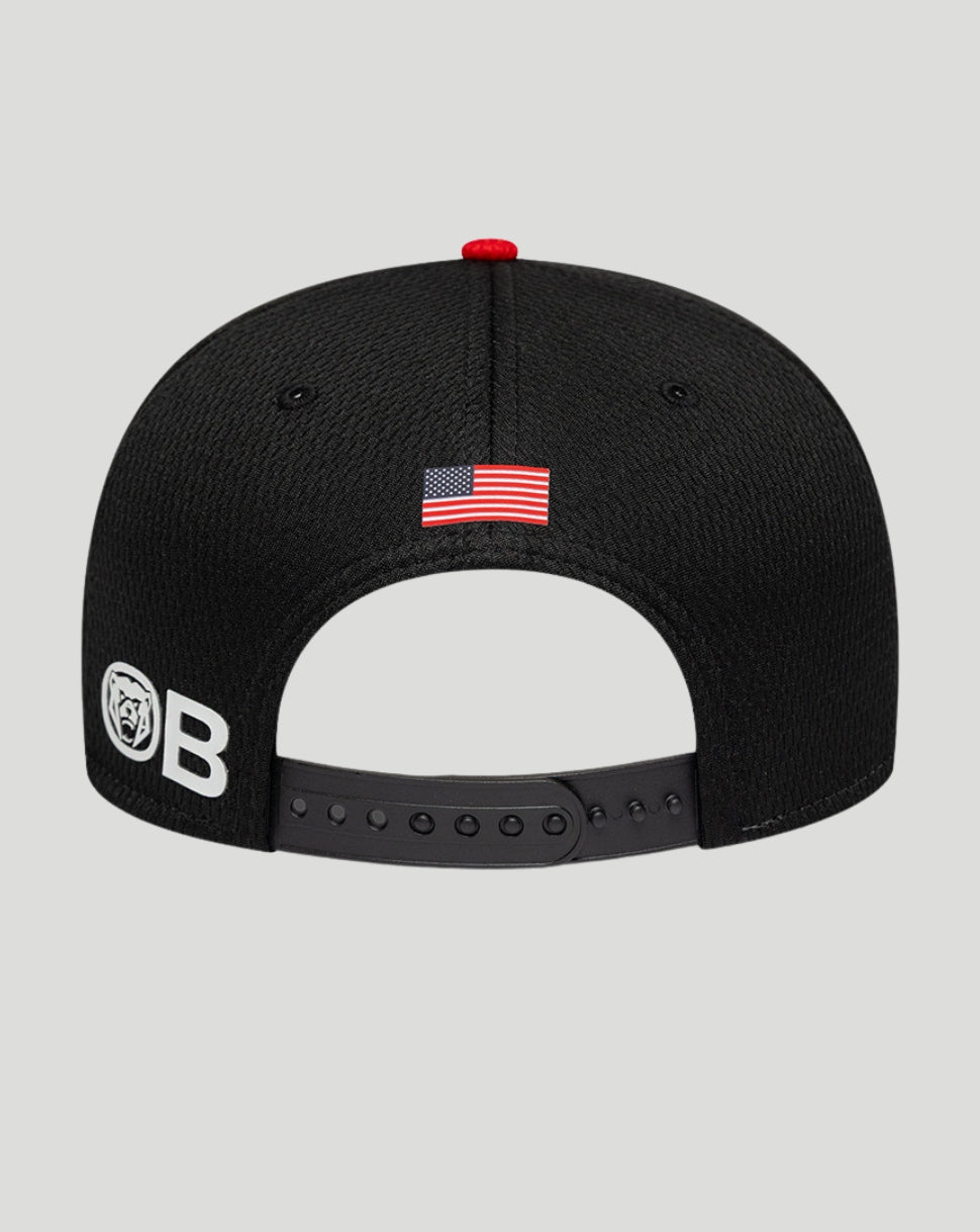 Black cap with American flag patch and logo on a gray background