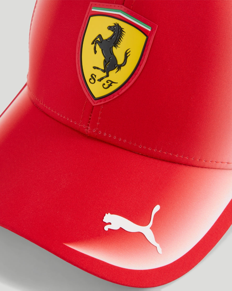 Red Ferrari cap front close-up showing the yellow shield crest with a black prancing horse and a white Puma logo on the brim.