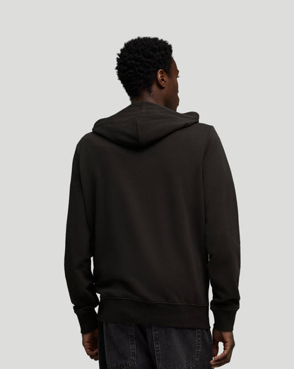 Back view of black McLaren hoodie on model showing hood and ribbed hem