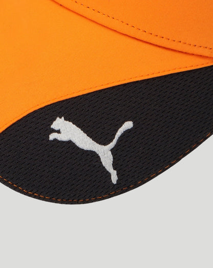 Close up of orange cap fabric showing white Puma logo on a black patch