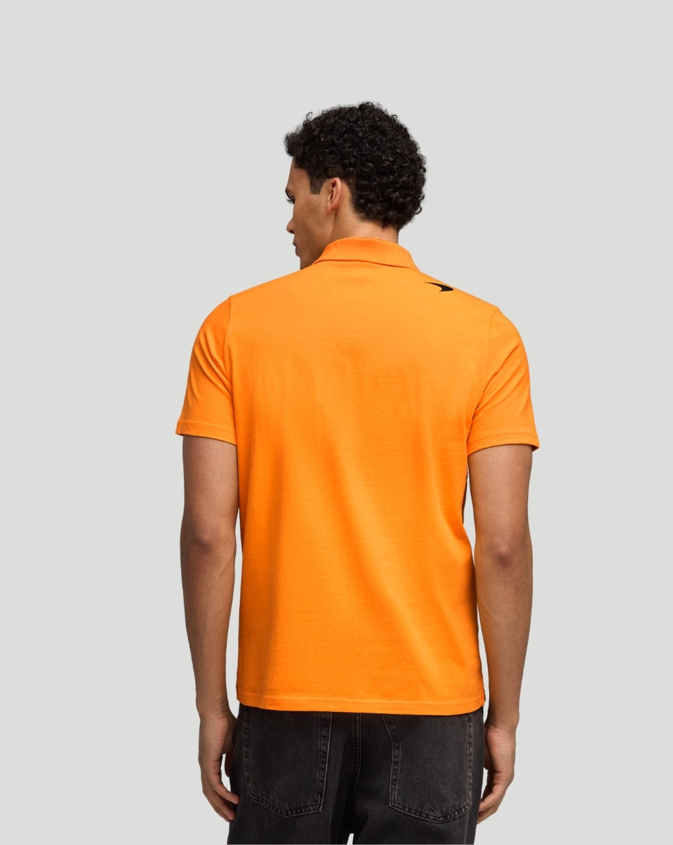 Back view of a papaya McLaren polo worn by a man with a small logo on the upper back