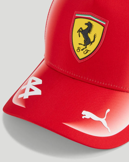 Close-up of red Ferrari cap showing yellow shield crest and white 44 design on the brim
