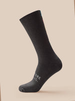 Black sock with a brand logo on a beige background