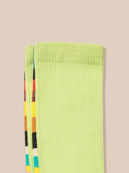 Light green sock with colorful stripes on a beige background