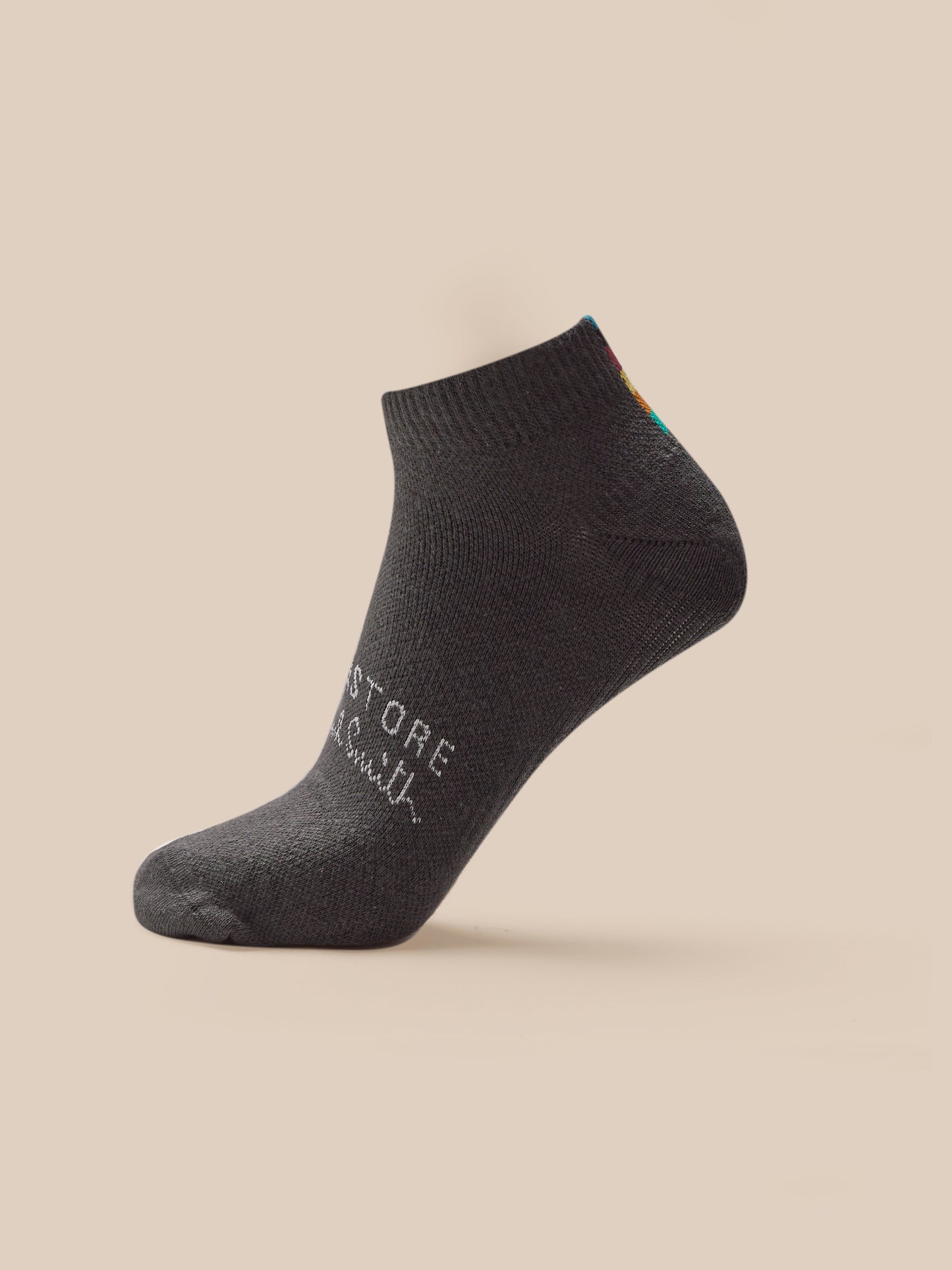 Dark gray ankle sock with text on a beige background