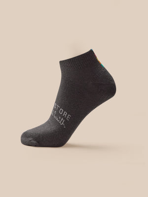 Dark gray ankle sock with text on a beige background