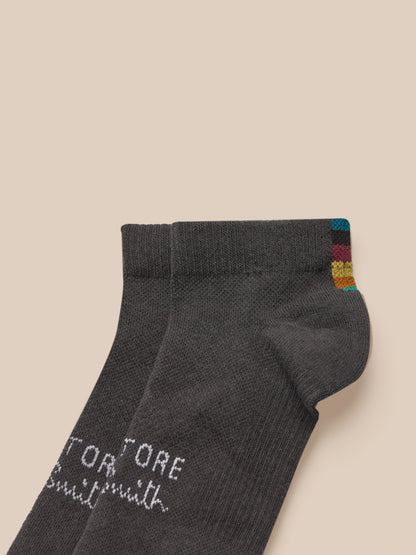 Dark gray sock with brand name on a beige background