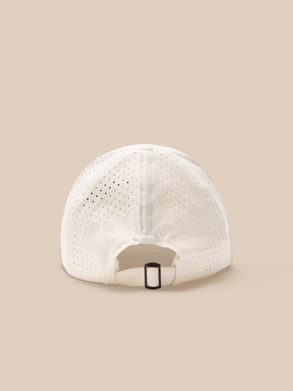 White baseball cap with perforated design on a beige background