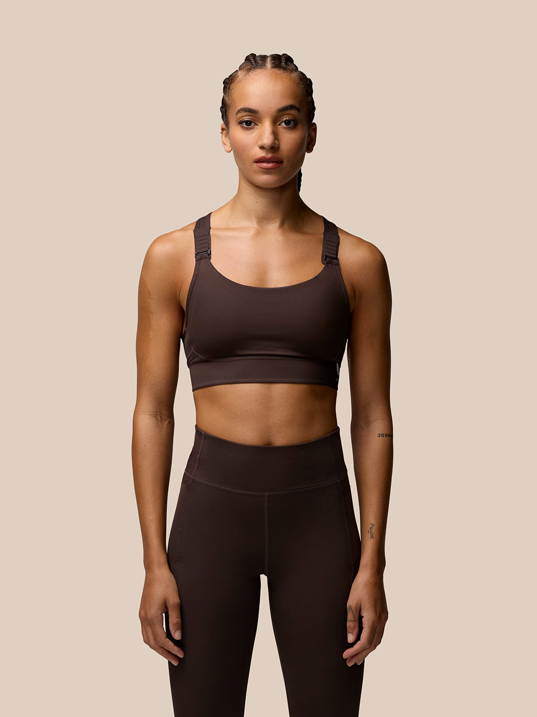 Front view of a model wearing brown Zone Training Sports Bra with scoop neckline and racerback.