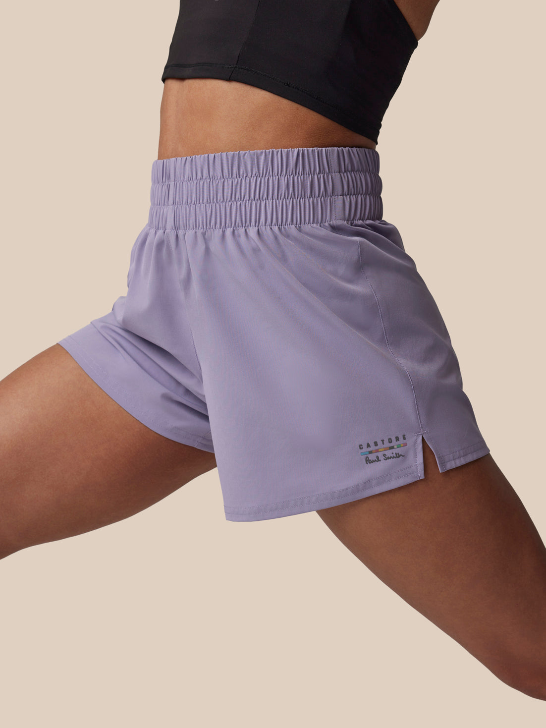 Person wearing light purple athletic shorts on a beige background