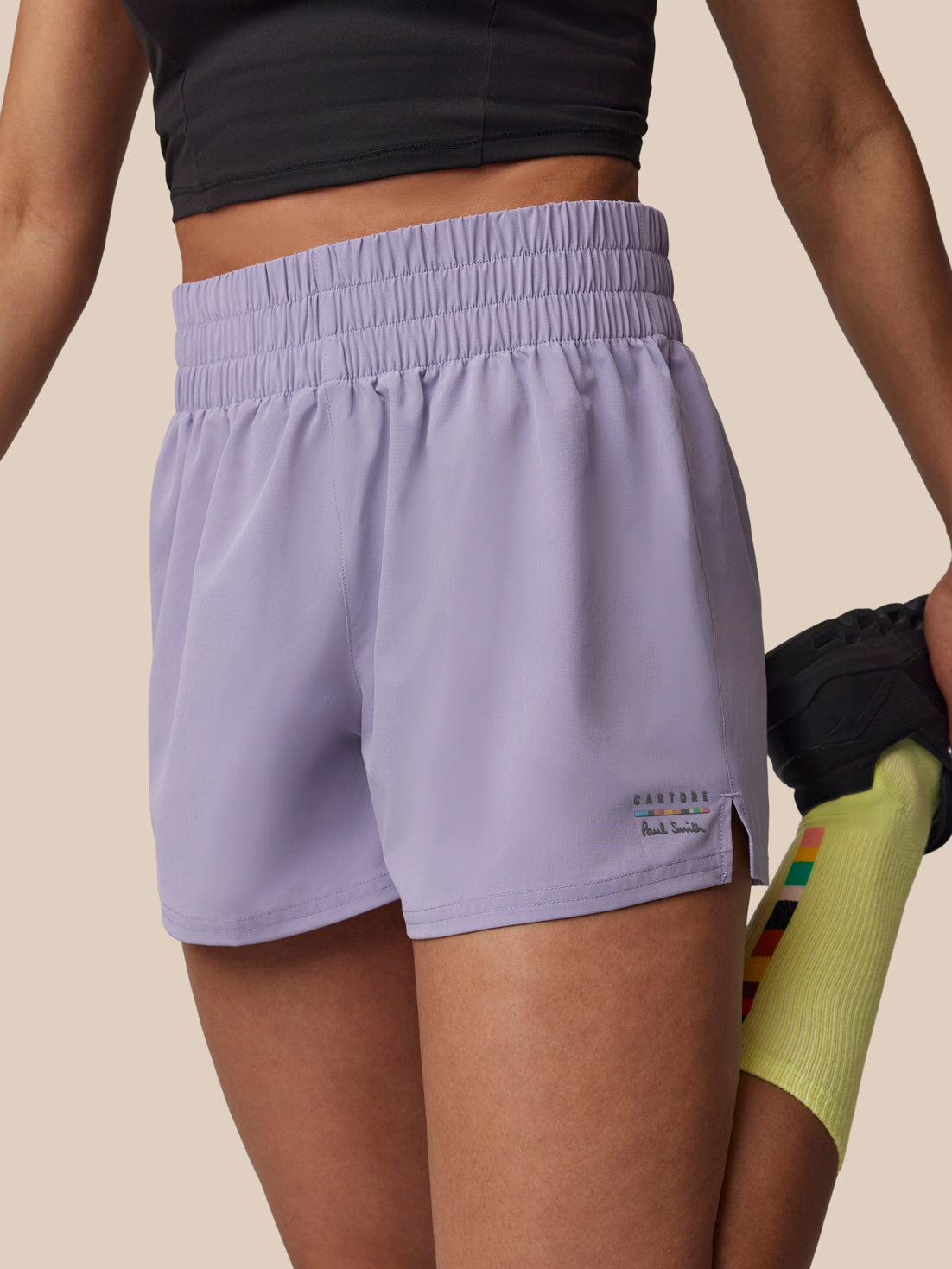 Person wearing light purple athletic shorts on a beige background