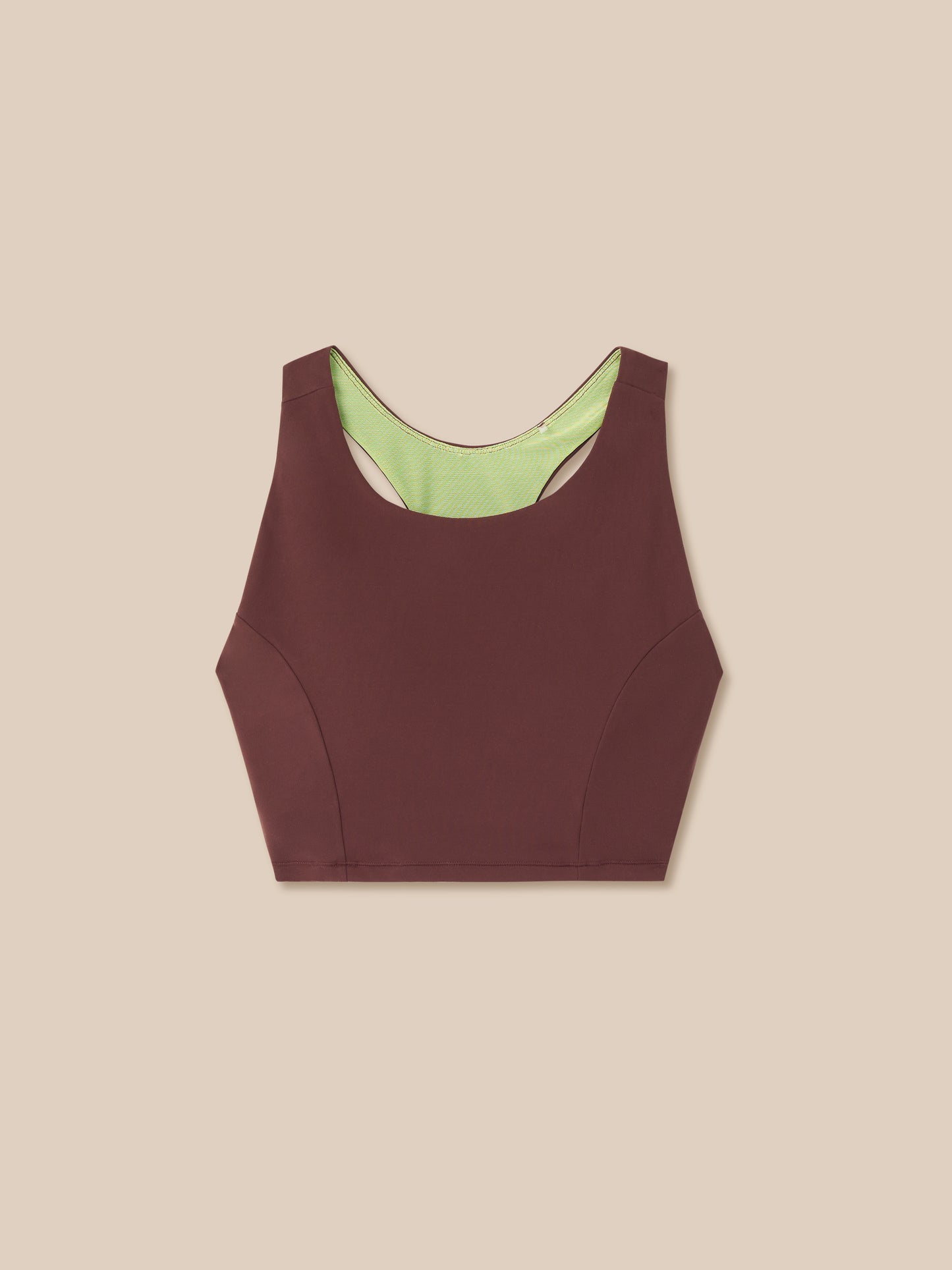 Brown sports bra with green lining on a beige background
