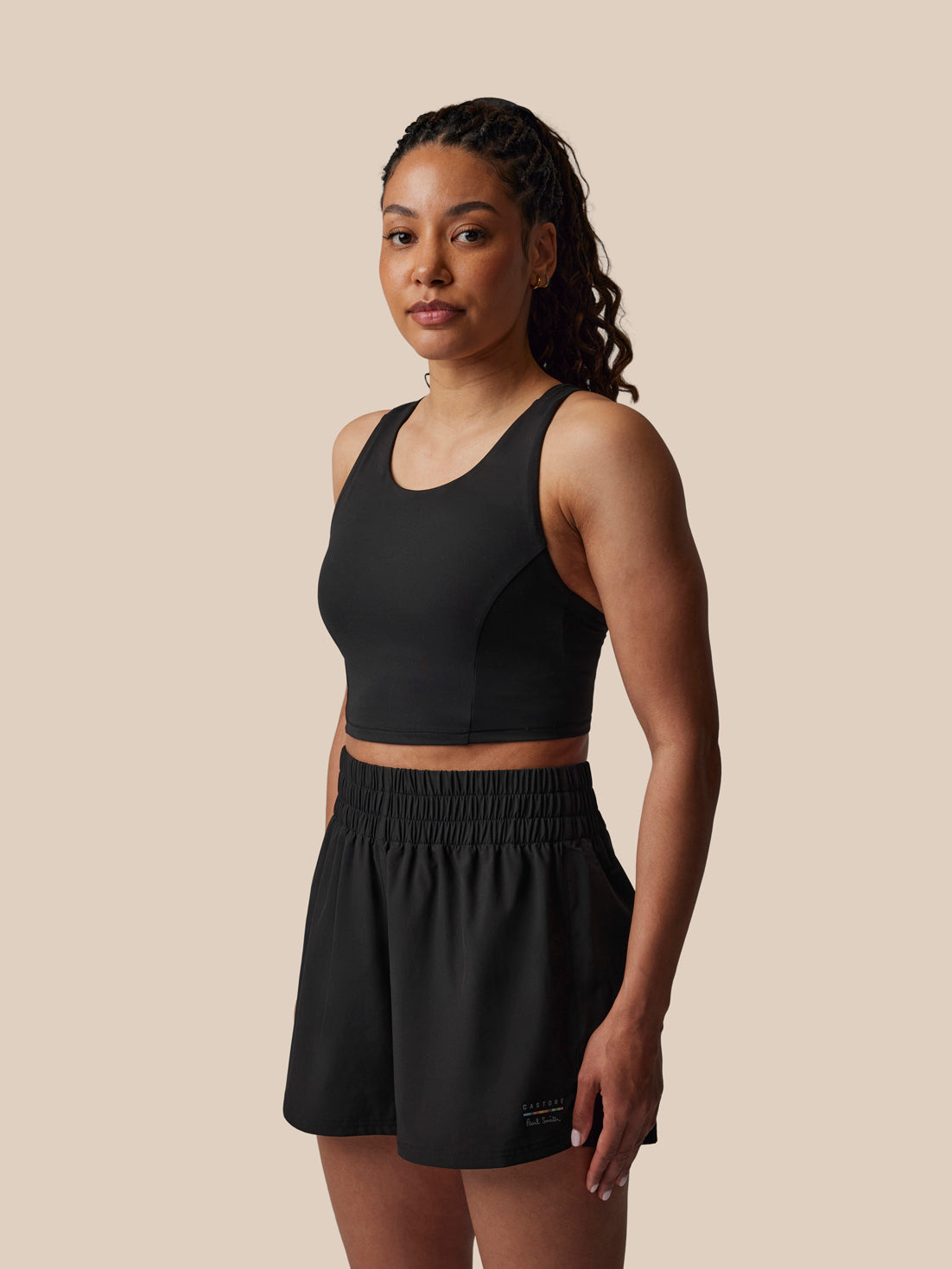 Woman wearing a black athletic outfit on a beige background