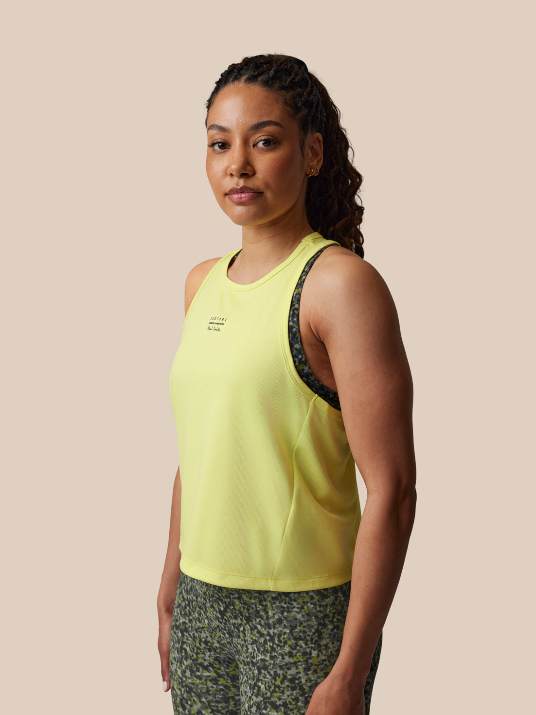 Woman wearing a yellow tank top on a beige background