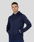 Male model wearing navy flex zip-through hoodie with hood and Castore logos on chest and sleeve.