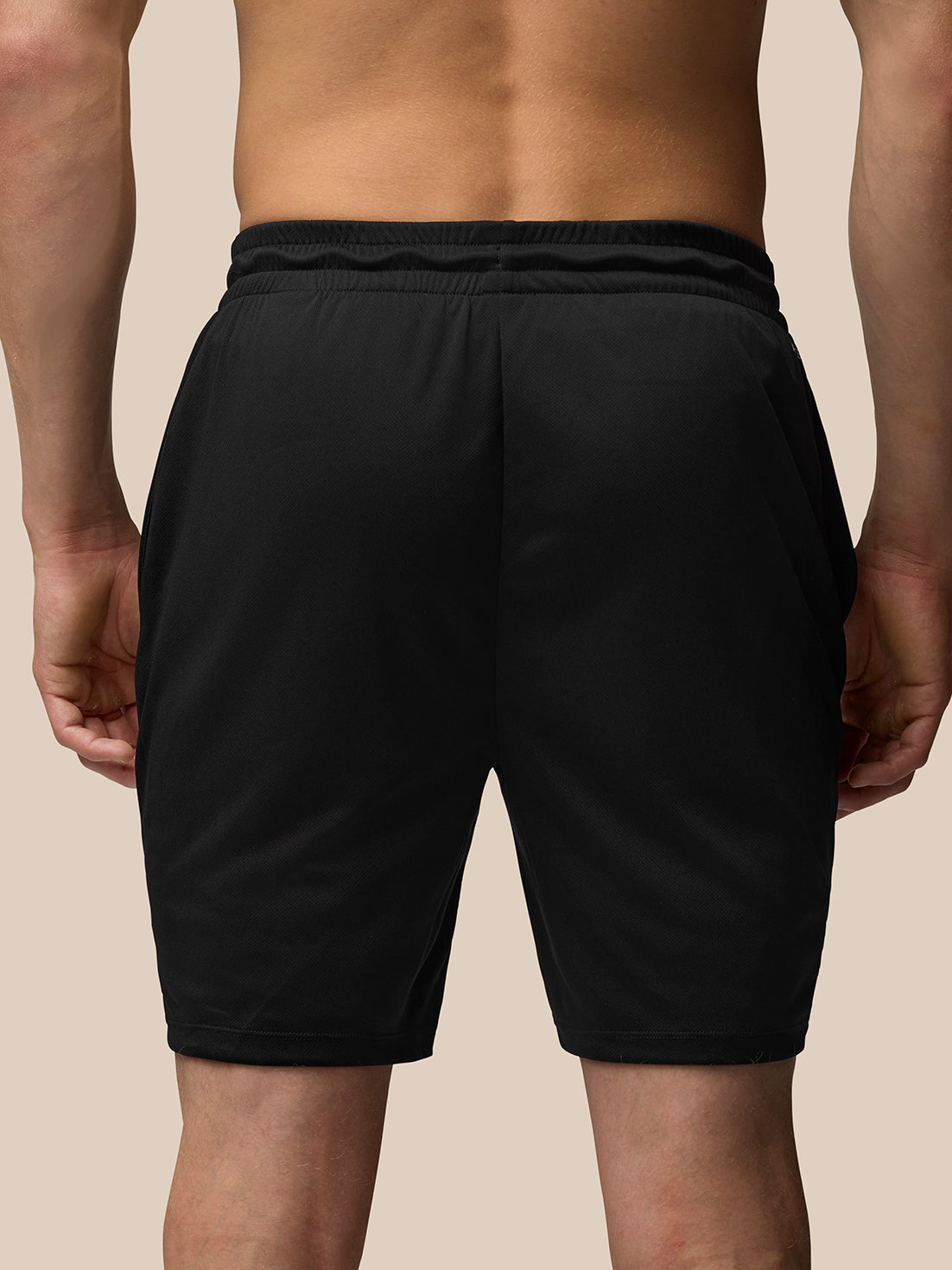 Back view of a man in black Adapt Training Shorts with an elastic waistband.