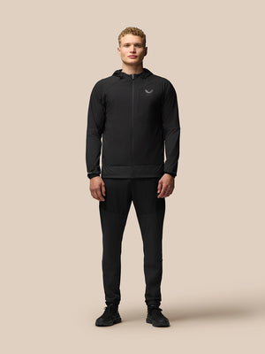 Male model wearing black Winterised Flex Joggers with elastic cuffs and a matching jacket