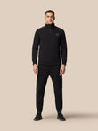 Full body front view of a man wearing black Adapt Fleece Joggers with zip pockets and a drawstring waistband