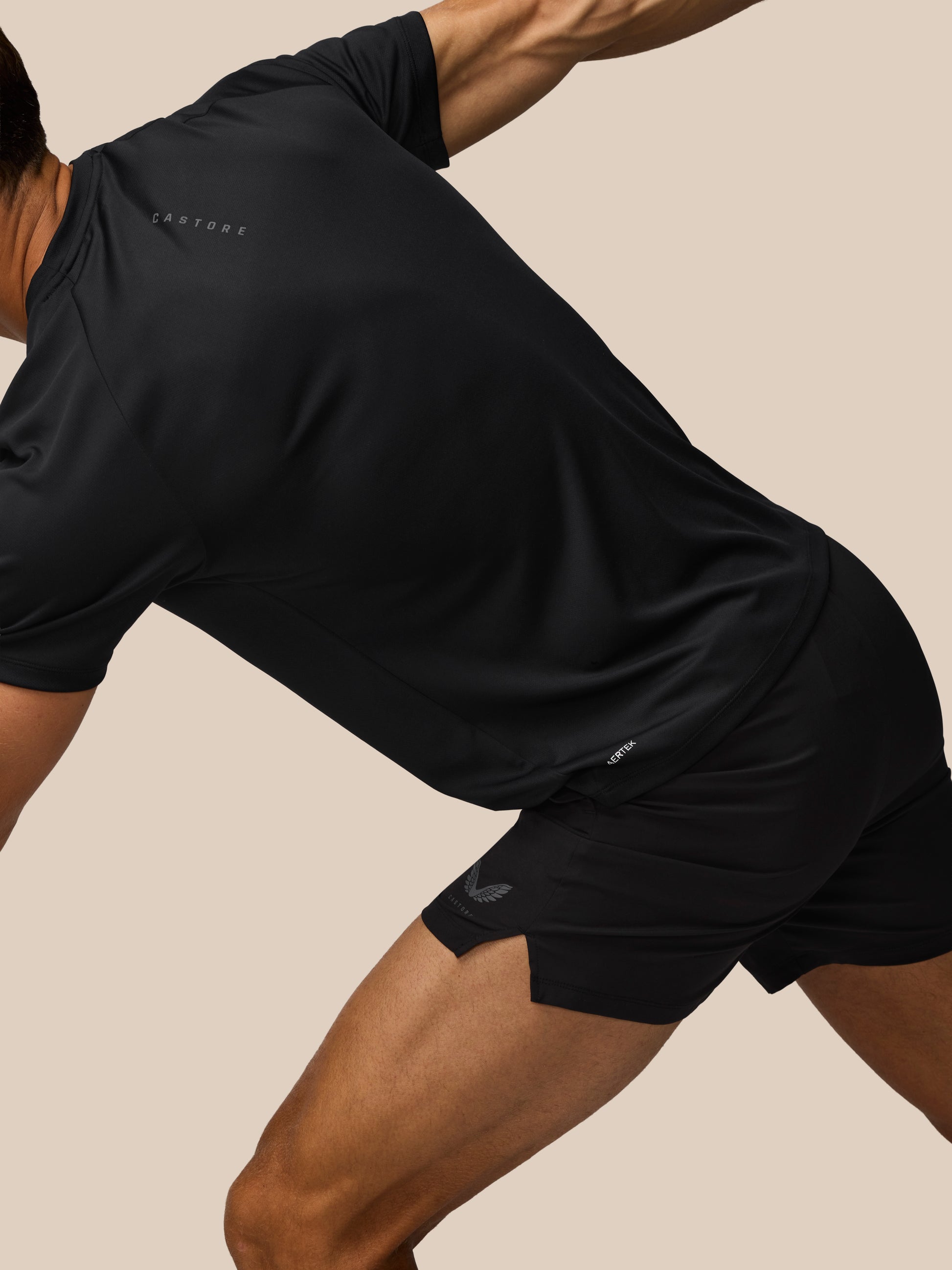 Person wearing black athletic shorts and a shirt on a beige background