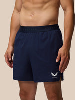 Navy athletic shorts with a brand logo on a beige background