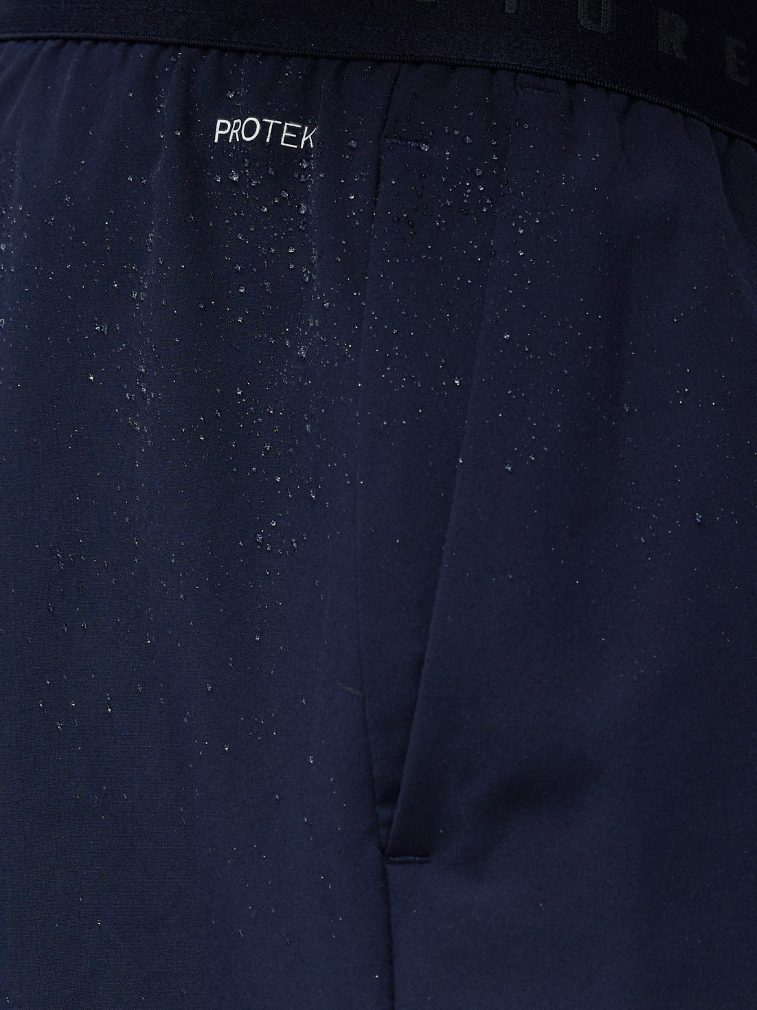 Close-up of a dark blue fabric with 'Protek' branding.