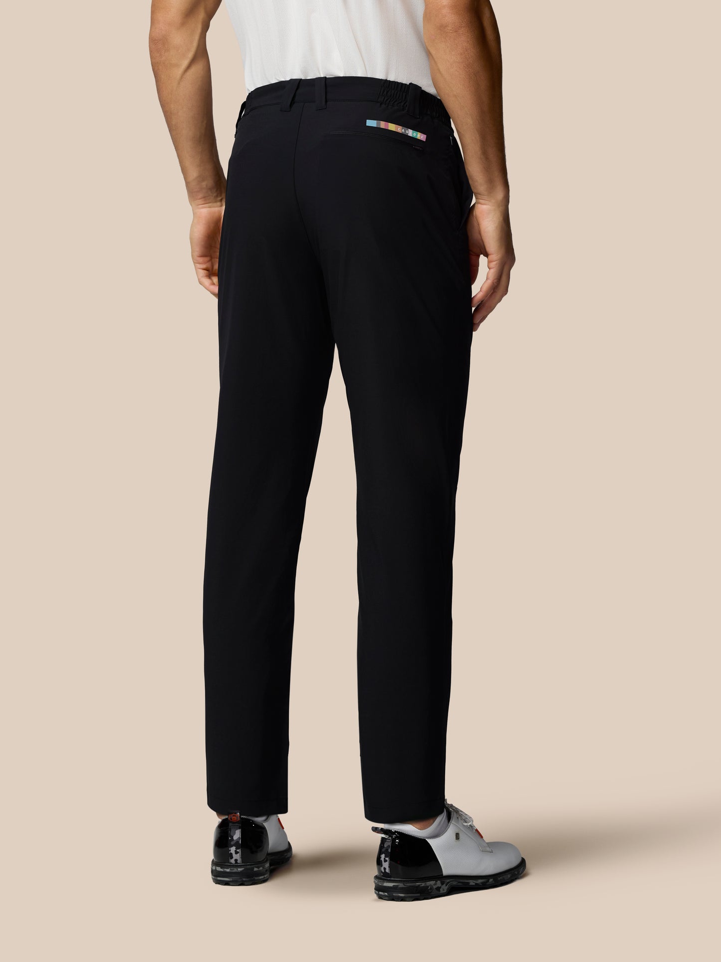 Person wearing black pants on a beige background
