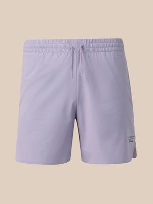 Light lavender athletic shorts with an elastic waistband and drawstring, shown against a solid beige background.