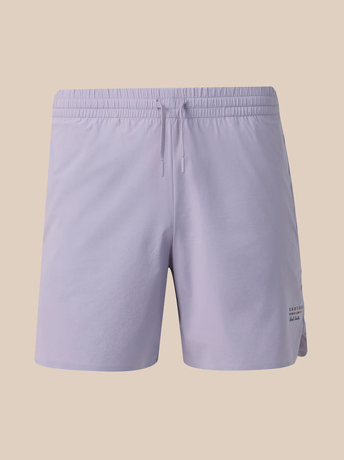 Light lavender athletic shorts with an elastic waistband and drawstring, shown against a solid beige background.