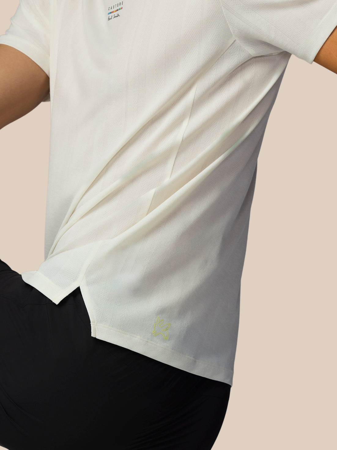 White t-shirt with a small logo on a light pink background