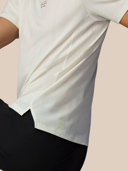 White t-shirt with a small logo on a light pink background
