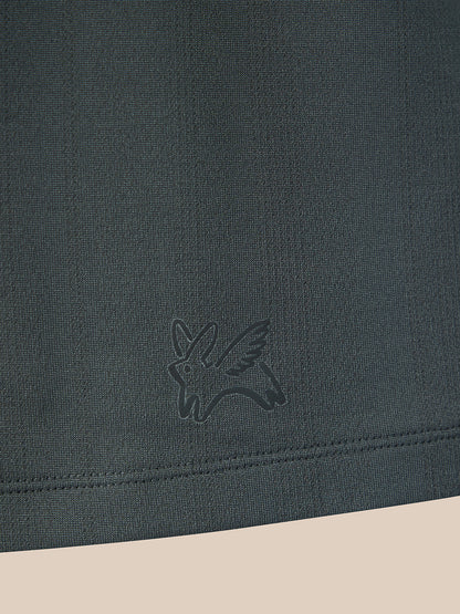 Close-up of a dark charcoal gray knit fabric with a tonal embroidered bird logo near the hem, shown against a light beige background.