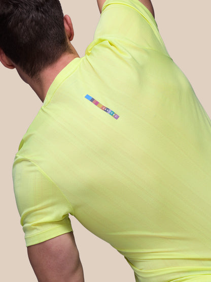 Person wearing a bright yellow athletic outfit with a brand logo on a plain background