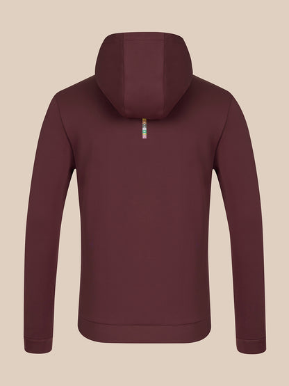 A dark plum-colored zip-up hoodie shown from the back, featuring a small vertical metallic zipper pull with a colorful logo, set against a solid beige background.