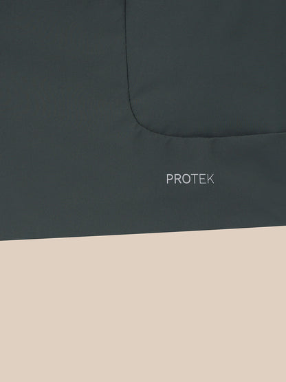 Close-up of a dark charcoal gray fabric surface with a curved seam and the word PROTEK printed in small white text, with the lower half of the frame filled with a light beige block.