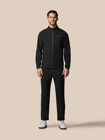 Man wearing a black tracksuit on a beige background
