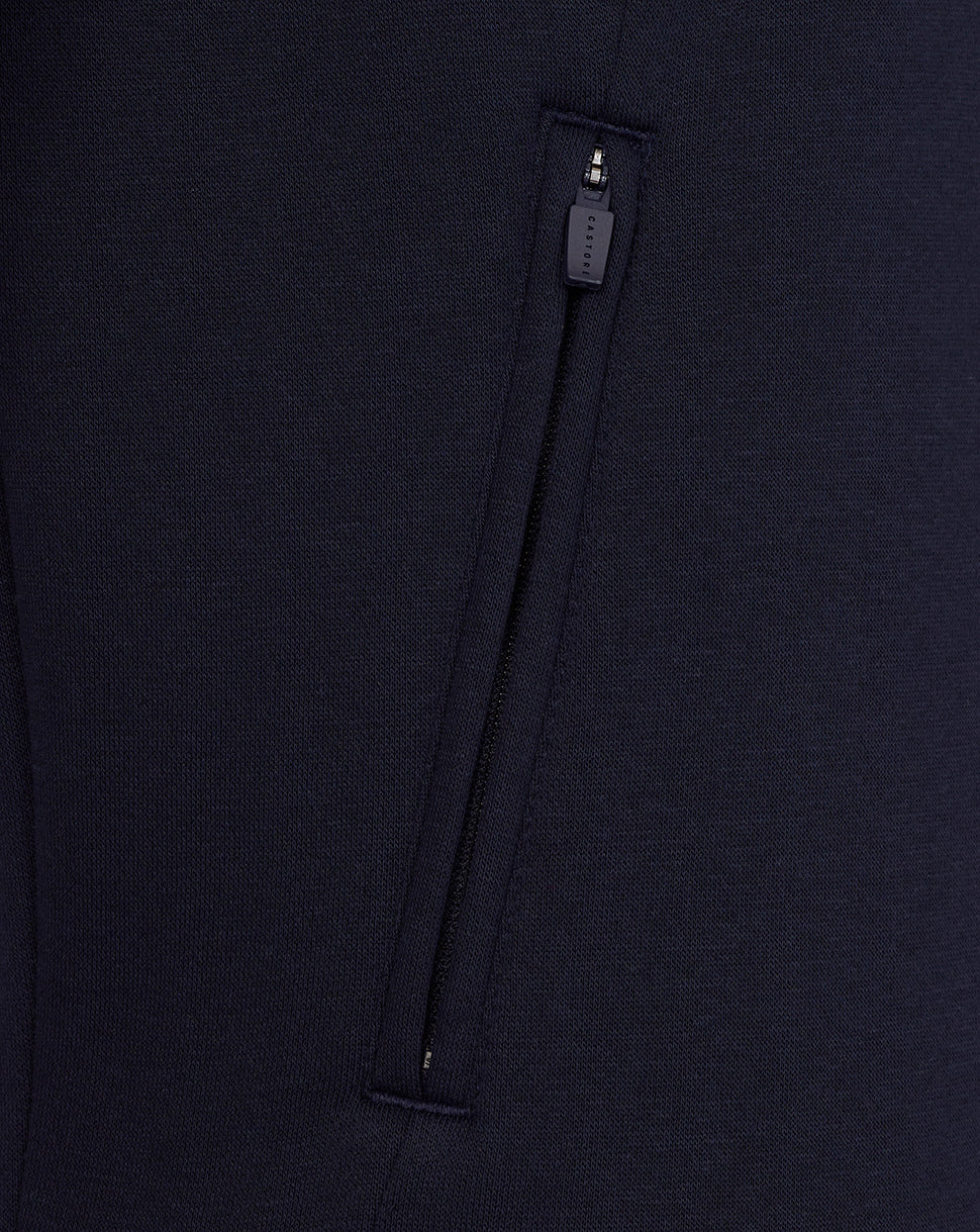 Close-up of a navy blue garment with a zipper detail on a matching background