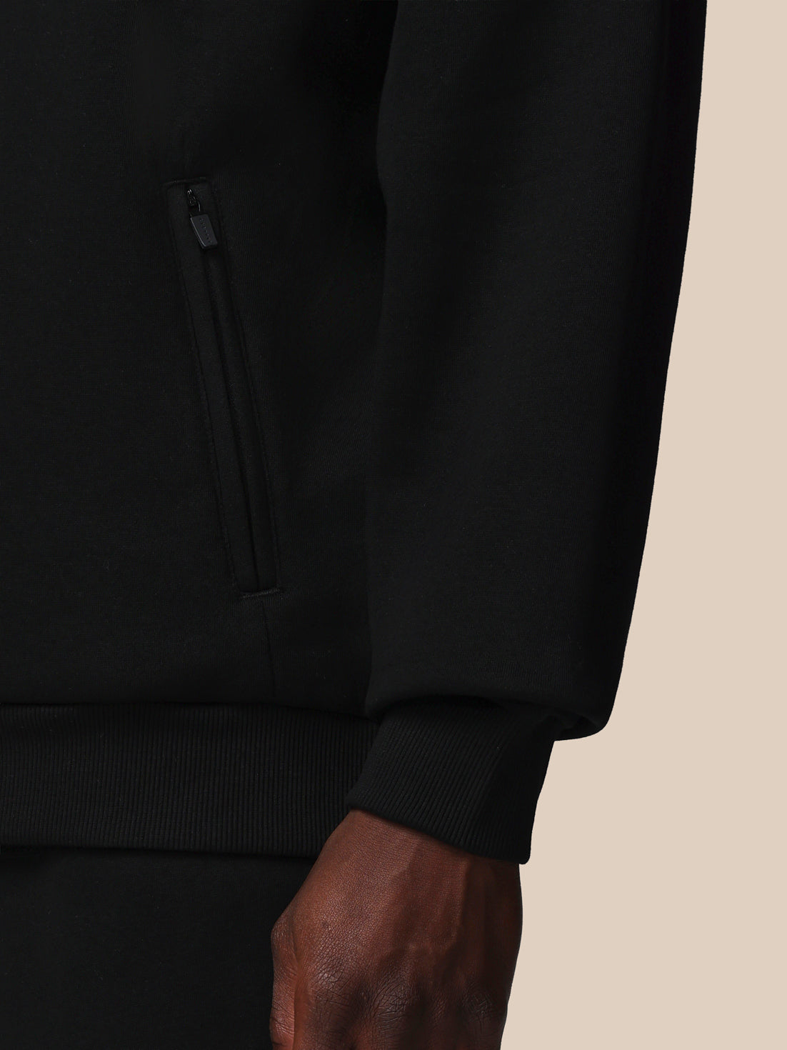 Close-up of a black hoodie on a beige background