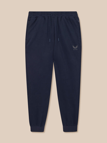 Navy blue jogger pants with a logo on a beige background