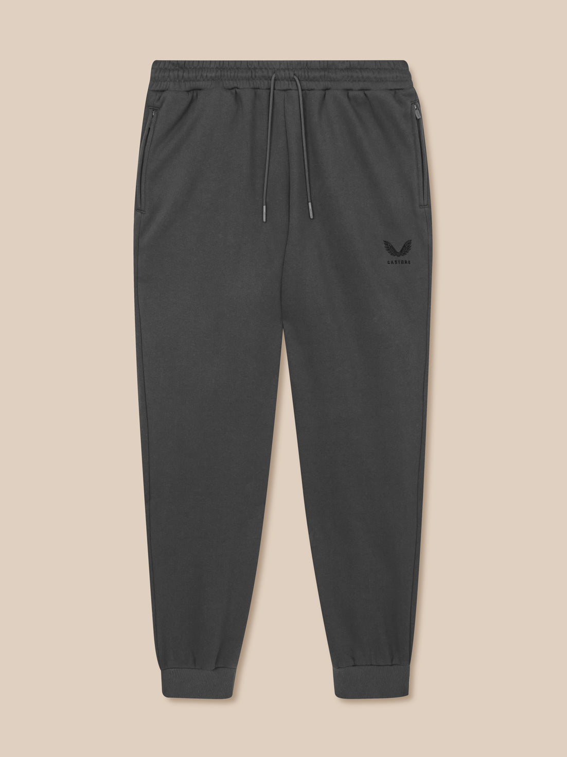 Dark gray jogger pants with a brand logo on a beige background