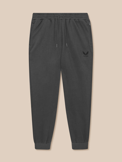 Dark gray jogger pants with a brand logo on a beige background