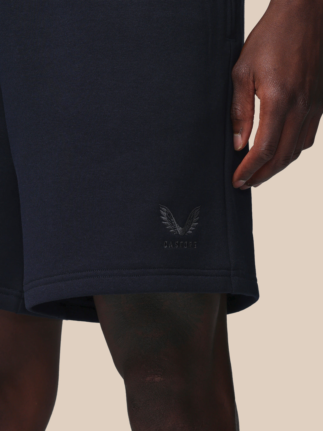 Navy blue shorts with a logo on a beige background