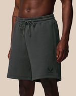Dark gray shorts with a brand logo on a beige background