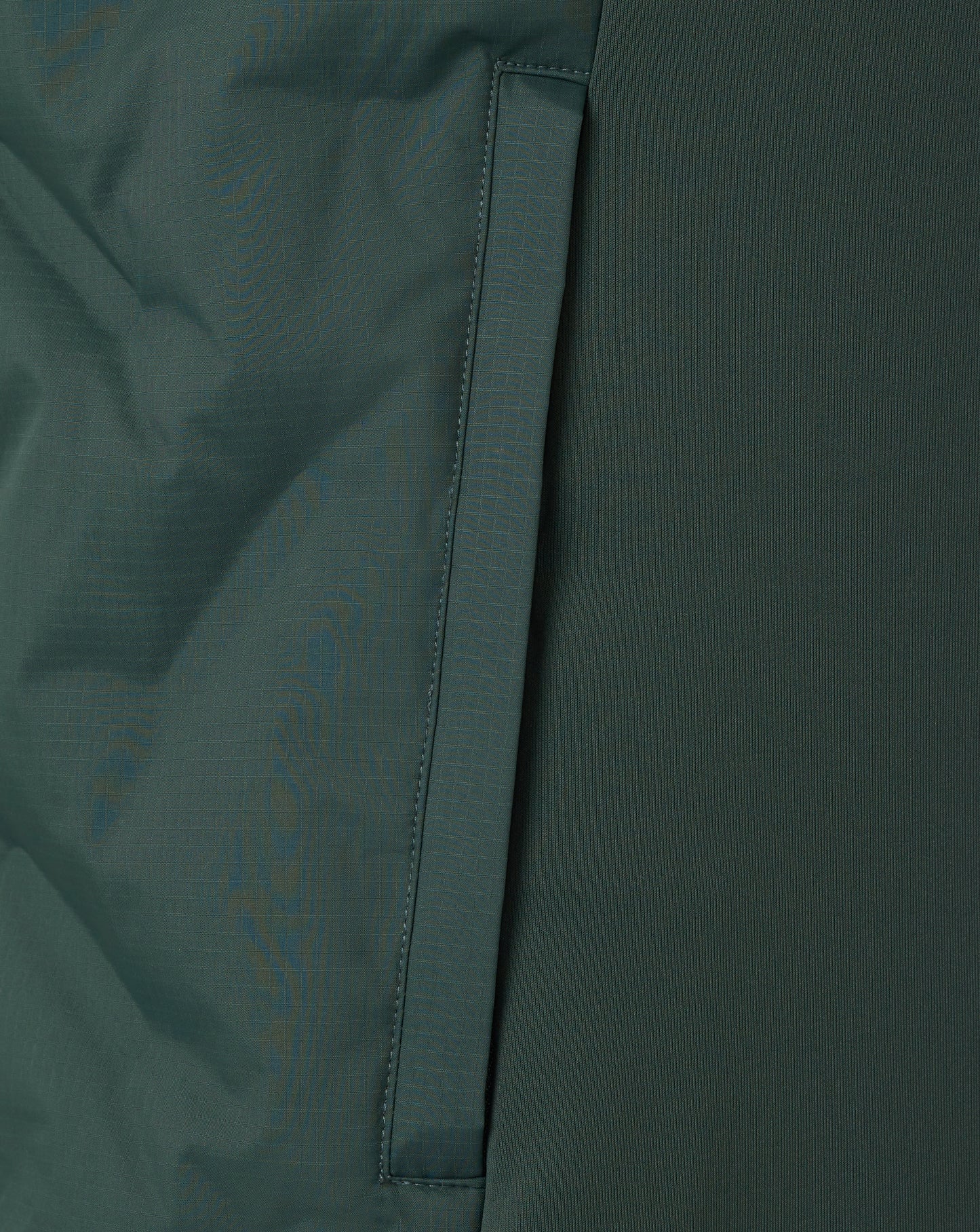 Close-up of a dark green fabric with a visible seam