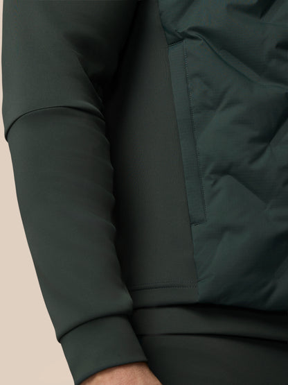 Close-up of a dark green jacket with a beige background