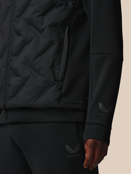 Black jacket with brand logo on sleeve against a beige background